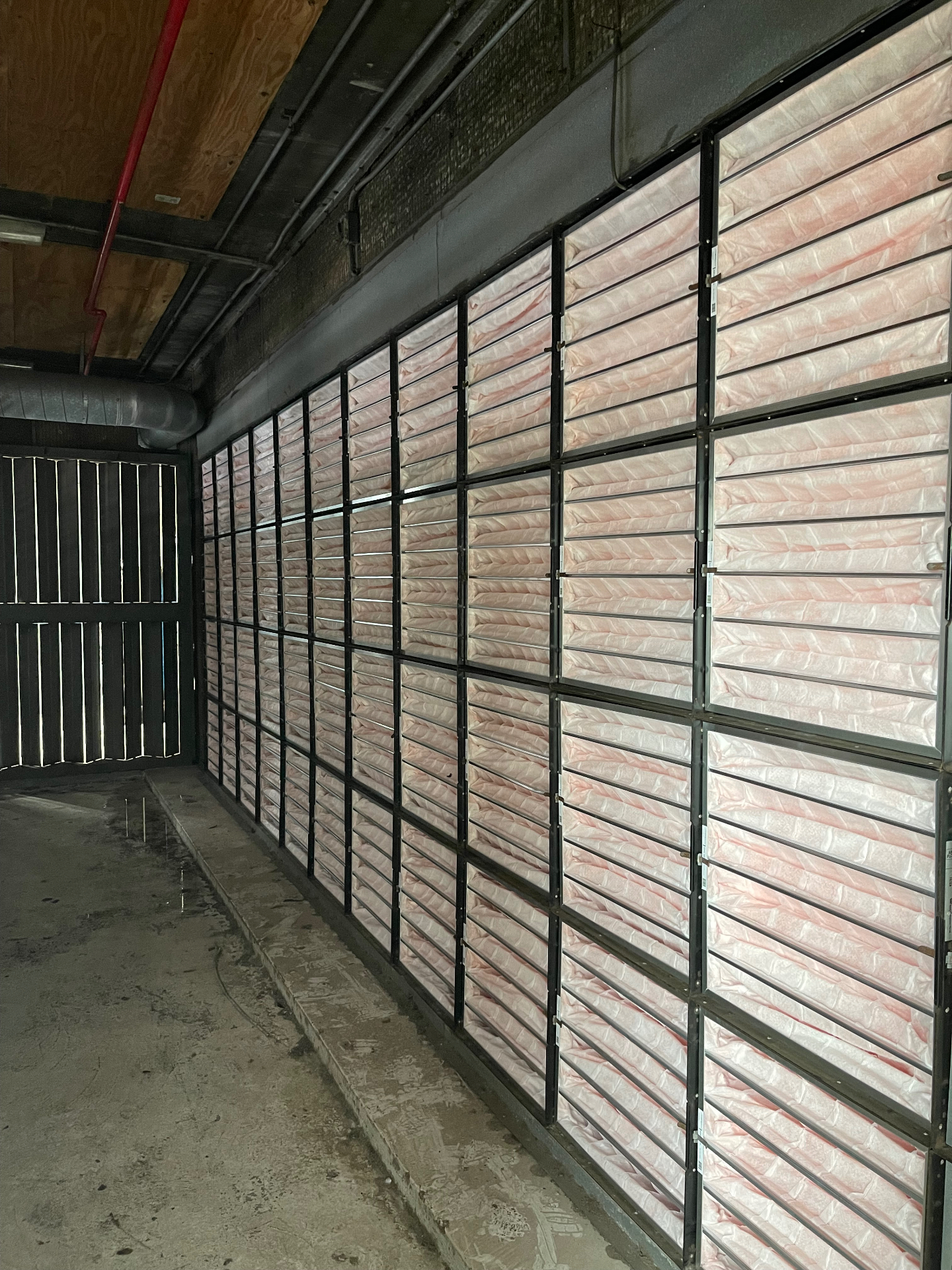 Large commercial HVAC filter wall with fresh pink pleated air filters in a plant room
